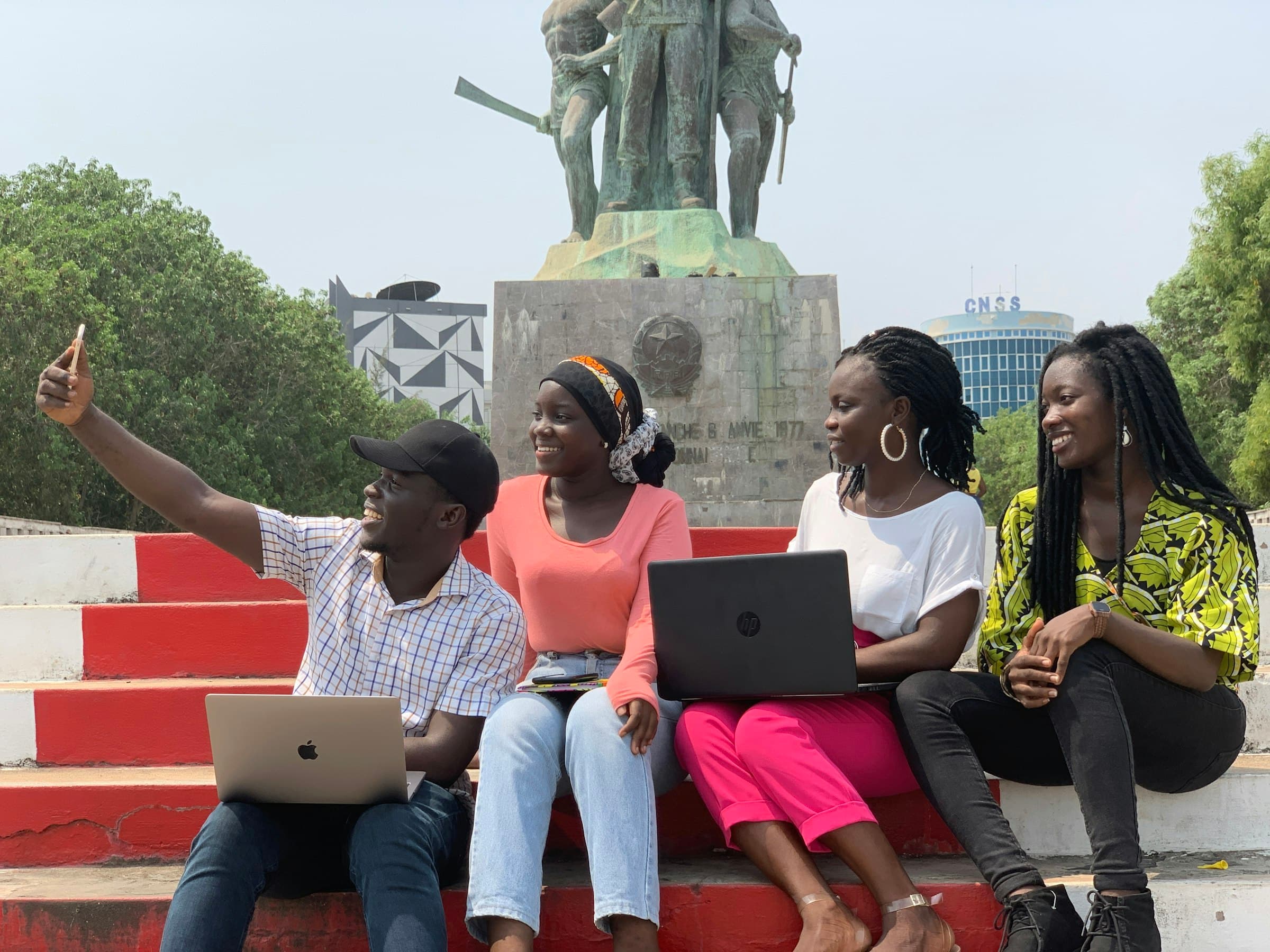 Students with laptops sitting together on campus